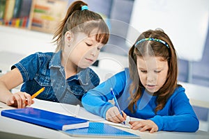 Schoolgirls learning in classroom photo