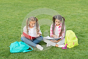 Schoolgirls little children school yard with books, interesting reading concept