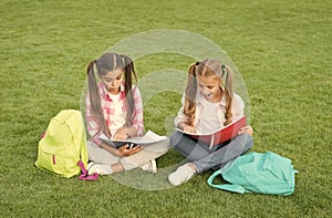 Schoolgirls little children school yard with books, interesting reading concept