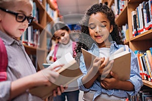 schoolgirls looking for books in library