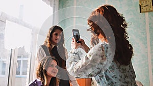 Schoolgirls taking photos of themselves on their phones in class.