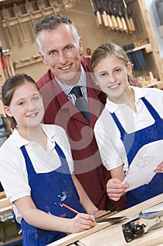 Schoolgirls and teacher in woodwork class