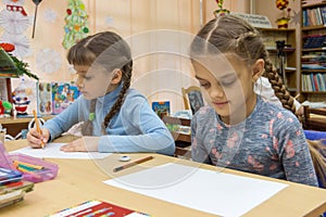 Schoolgirls at their desks in drawing class