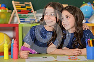 Schoolgirls twins on lesson of art