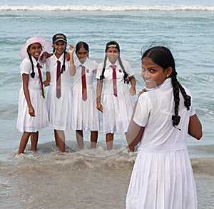 Schoolgirls in uniform playing on the beach