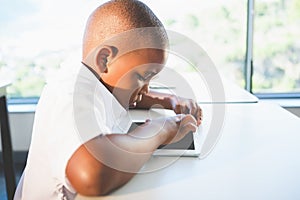 Schoolkid using digital tablet in classroom