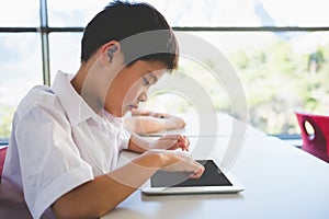 Schoolkid using digital tablet in classroom