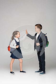 schoolkids with backpacks giving high five