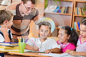 Schoolkids and their teacher at lesson