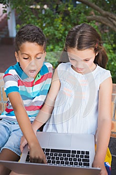 Schoolkids using laptop in school campus