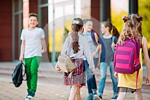 Schoolmates go to school. Students greet each other.