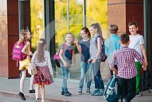 Schoolmates go to school. Students greet each other.