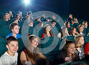 Schoolmates watching cartoon in the cinema hall.