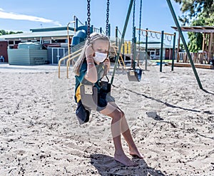 Schools closures Coronavirus lockdown. Bored school kid alone in playground feeling sad and lonely