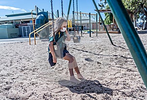 Schools closures Coronavirus lockdown. Bored school kid alone in playground feeling sad and lonely