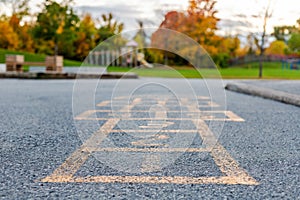 School and schoolyard with hopscotch and playground for elementary students in evening in fall season