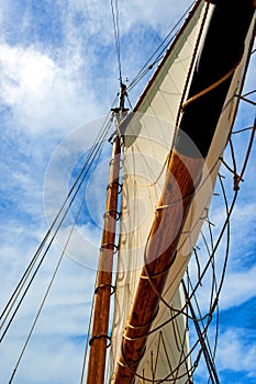 Schooner mast and sails against blue sky