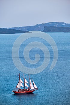 Schooner vessel ship boat in Aegean sea near Santorini island with tourists going to sunset viewpoint