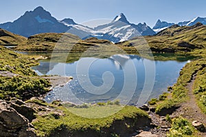 Schreckhorn, Jungfrau and Wetterhorn peaks in Bernese Alps reflecting in lake Bachalpsee, Switzerland