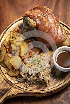 SCHWEINSHAXE traditional german pork knuckle with sauerkraut and potatoes meal