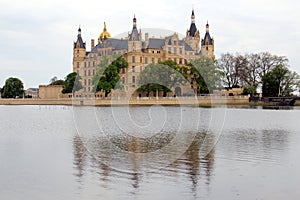 Schwerin Castle on the lake reflected in the water on a cloudy day