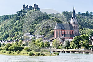 Schönburg Castle on the river Rhine, towering above the town of Oberwesel with its colourful Gothic church