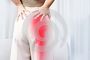 Sciatica Pain concept with woman suffering from buttock pain spreading to down leg photo