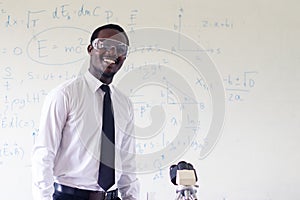 Science african teacher standing in front of blackboard teaching student in classroom