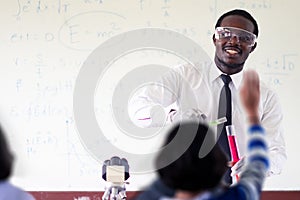 Science african teacher standing in front of blackboard teaching student in classroom