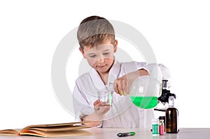 Science boy pours liquid from flask into glass