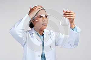 Science can blow your mind. an attractive young female scientist looking shocked while examining a beaker filled with