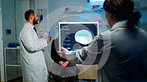 Science doctor looking at computer with medical brain scan film