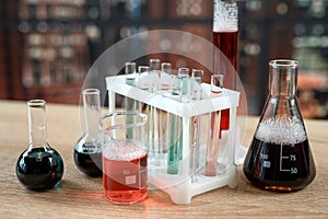 Science experiment laboratory flasks with different multi-colored liquids on desk