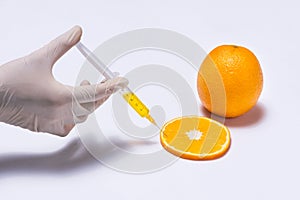 Science experiment with orange and syringe isolated on white.