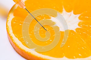 Science experiment with orange and syringe isolated on white.