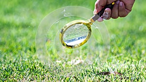 Science experiments. Learn to combine the sun`s rays with magnifying glass. Human hand holding golden magnifying glass.