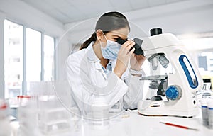 Science is but an image of the truth. a young scientist using a microscope in a lab.