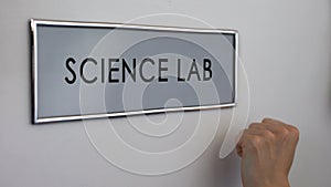 Science lab door, hand knocking close up, chemical experiments, biology research