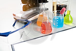 Science lecture clipboard with chemical experiment in school laboratory with beakers, microscope for testing.