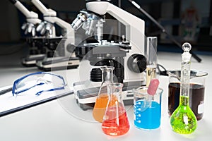 Science lecture clipboard with chemical experiment in school laboratory with beakers, microscope for testing.