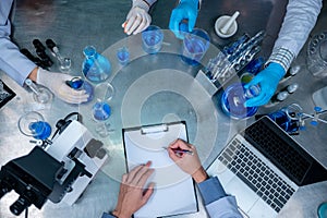 Science and medicine, scientist analyzing and dropping a sample into a glassware, experiments containing chemical liquid in