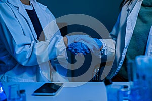 Science and medicine, scientist shaking hands, working together as a team