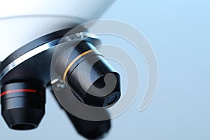 Science. Modern microscope on light blue background, closeup. Space for text