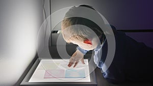 Science museum, little curious male child playing with color plates, child development