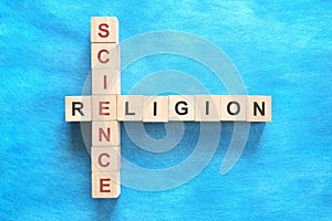 Science and religion relationship and interconnection concept. Crossword puzzle flat lay in blue background. photo