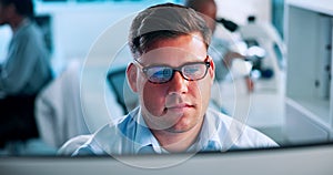 Science, research and man at computer thinking, reading and checking results in pharmaceutical study. Glasses