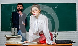 Science is sexy. Sexy girl sit table while man stand chalkboard. Flirting with colleague. Everyone dreaming about such