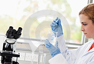 Science student dropping liquid in a beaker