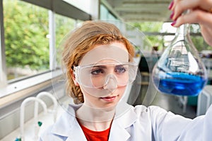 Science student looking at a flask