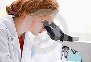 A science student looking into a microscope